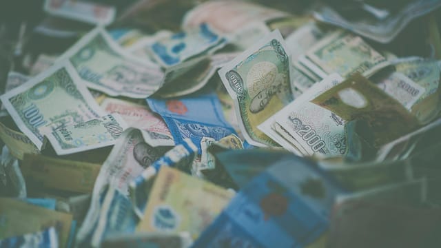 A close-up view of diverse international currency banknotes in soft focus, conveying wealth and finance themes.