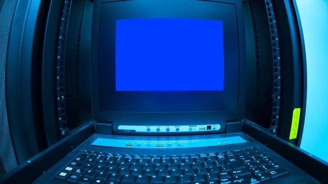 Illustrative image: Close-up of a blue screen error shown on a data center control terminal.