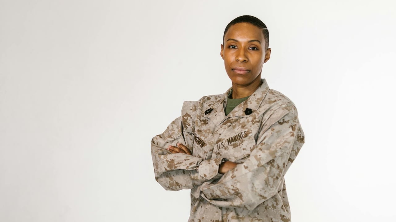 Portrait of a female African American soldier in a US Marines uniform on a white background.