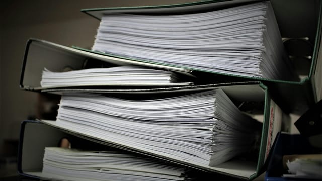 Close-up of stacked binders filled with documents for office or educational use.