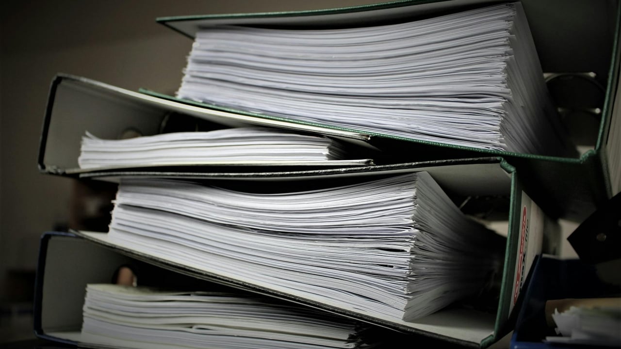Close-up of stacked binders filled with documents for office or educational use.