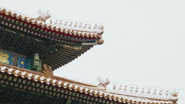 Intricate details of a traditional Chinese roof with ornate designs and vibrant colors.