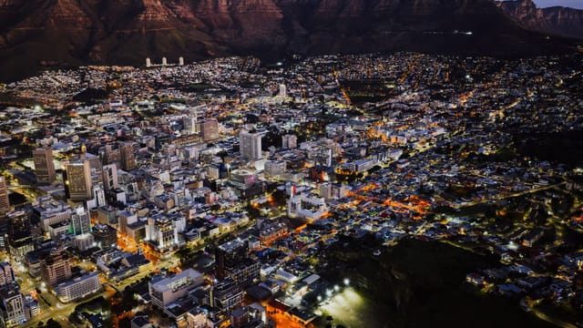 A stunning aerial view of Cape Town city lights at night against Table Mountain.