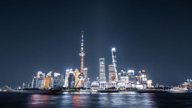 A stunning night view of Shanghai's illuminated skyline featuring the Oriental Pearl Tower.