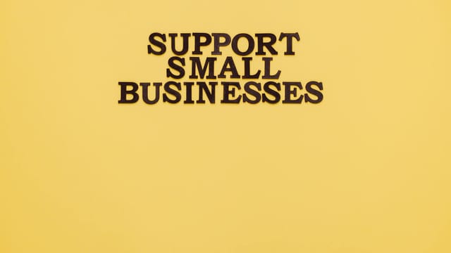Inspirational image with 'Support Small Businesses' text on a warm yellow background.