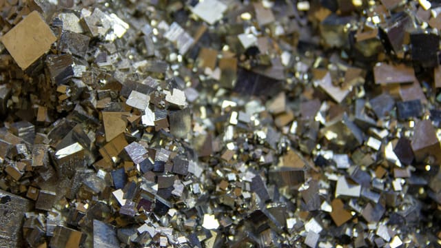 Detailed view of shiny pyrite crystals showcasing intricate metallic textures and patterns.
