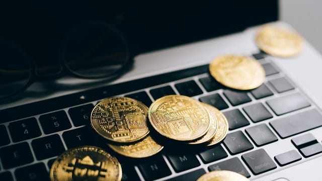 Close-up of gold bitcoins on a laptop keyboard symbolizing digital currency and technology.