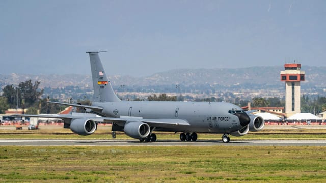A US Air Force KC-135 Stratotanker prepares for takeoff at an airfield.