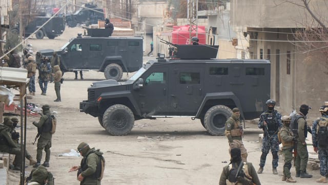 Armed forces in armored vehicles on the streets of Al Hasakah during a military operation.