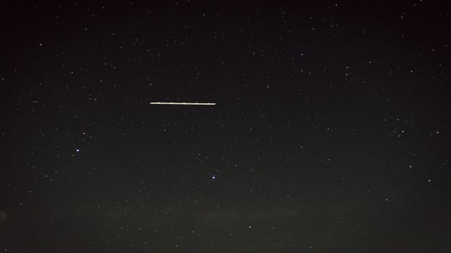 Captivating star-filled night sky with a mysterious line of light, captured in Germany.