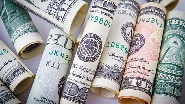 Close-up of rolled US dollar bills symbolizing wealth, financial success, and currency.