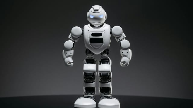 Close-up of a modern white robot with glowing eyes, symbolizing future technology and innovation.
