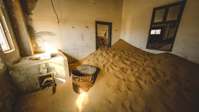 Eerie interior of an abandoned house filled with sand in Kolmanskop, Namibia.
