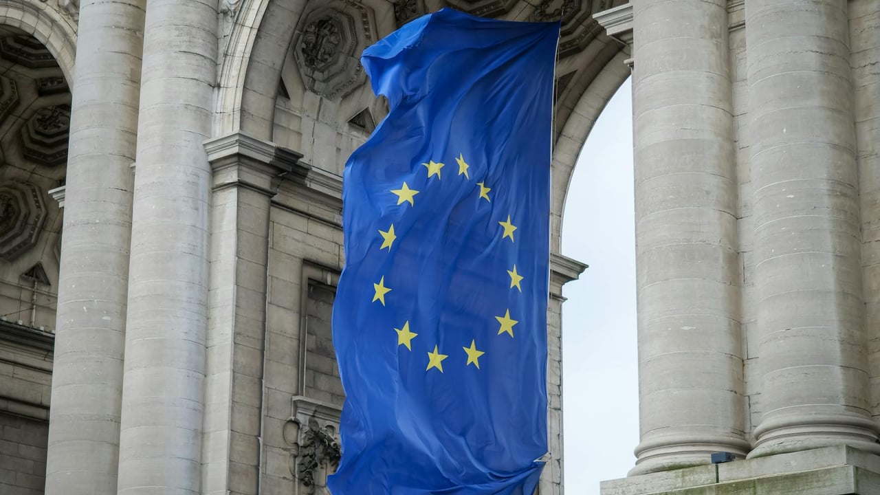 European Union flag fluttering beneath the Cinquantenaire Arch in Brussels, Belgium.