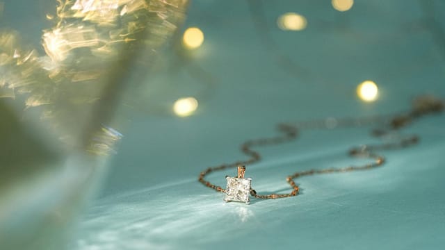 Close-up of a sparkling diamond pendant on a delicate chain, perfect for festive occasions.