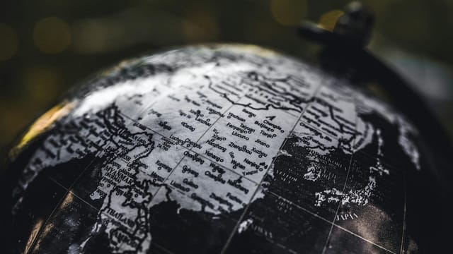Detailed black and white close-up image of a globe focusing on Asia, highlighting geographical details.