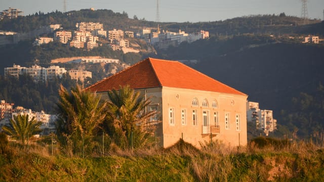 Picturesque rural house with red roof in Byblos, Lebanon hills at sunset.