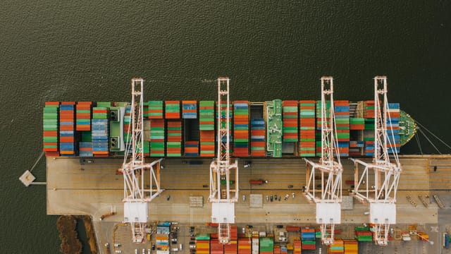 Overhead shot of colorful cargo containers and cranes at Baltimore's bustling port.