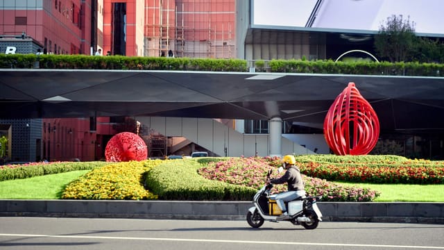 Explore a vibrant city scene in Shanghai featuring modern art and a scooter ride.