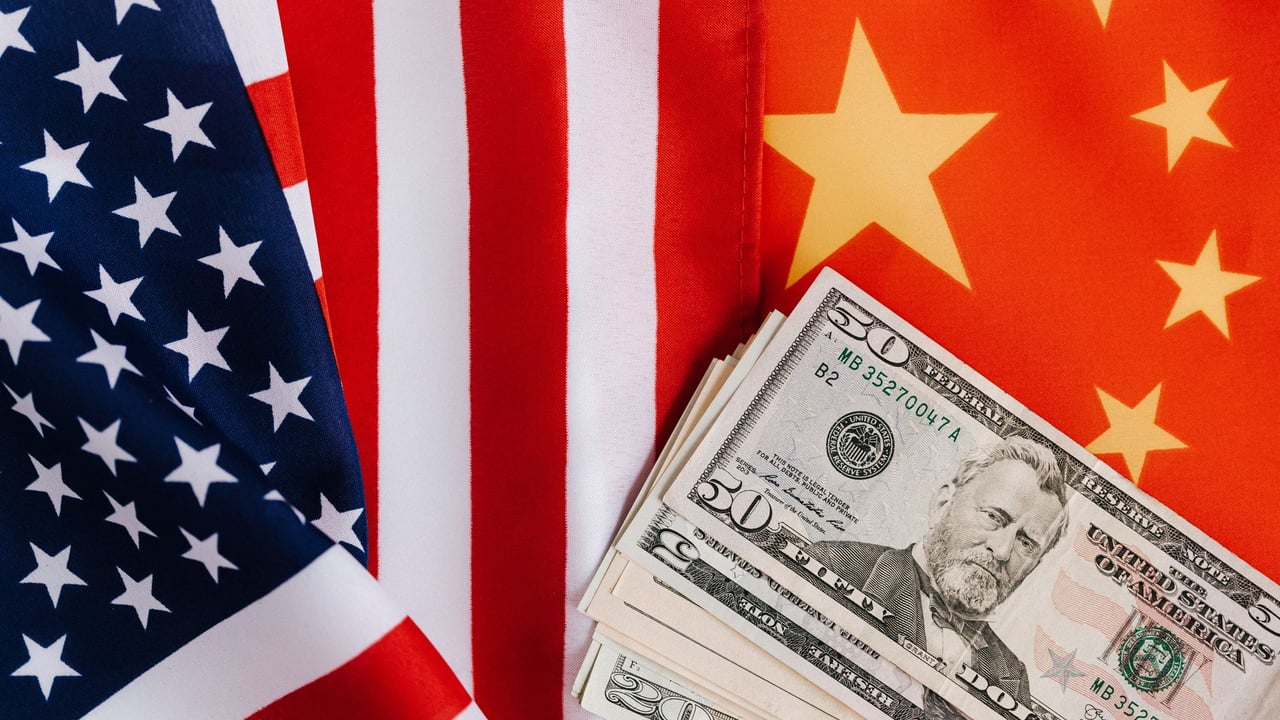 From above of United States banknotes placed on national flags of America and China illustrating international trade concept