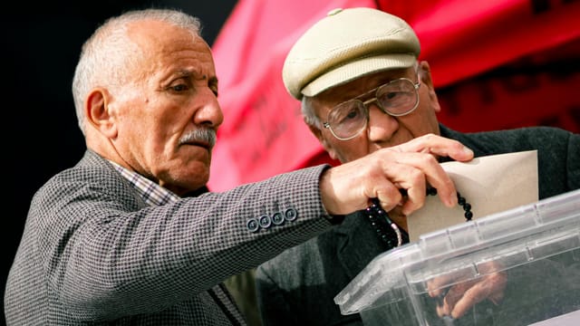 Two senior adults casting their votes at election polls, contributing to democracy.