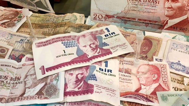 Turkish Lira banknotes of various denominations displayed, showcasing historical currency.