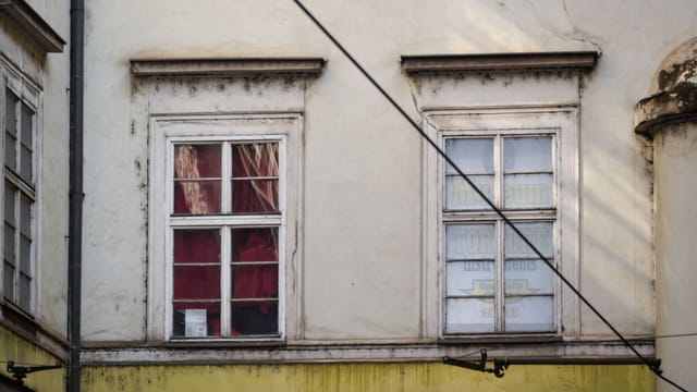 Vintage windows on a classic facade in Prague with intriguing textures and details.