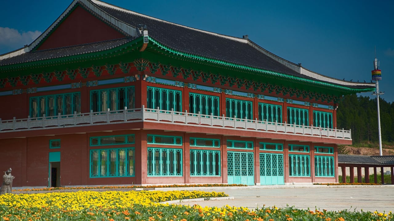 A stunning view of a traditional Korean building with colorful accents and a floral foreground.
