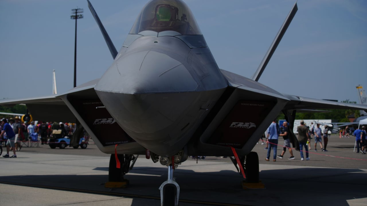 F-22 Raptor fighter jet on display at Charleston air show with spectators around.