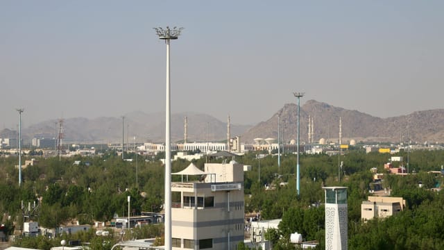 Aerial cityscape view featuring a mosque and mountains in Saudi Arabia.