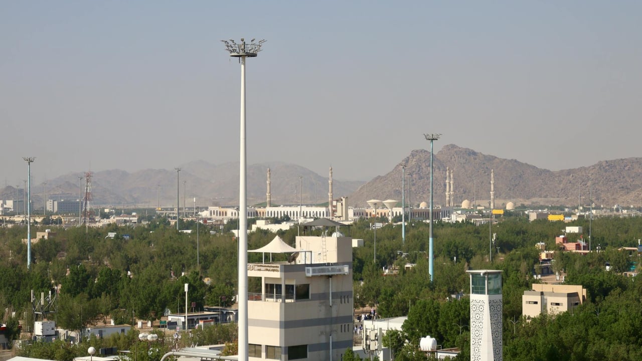 Aerial cityscape view featuring a mosque and mountains in Saudi Arabia.