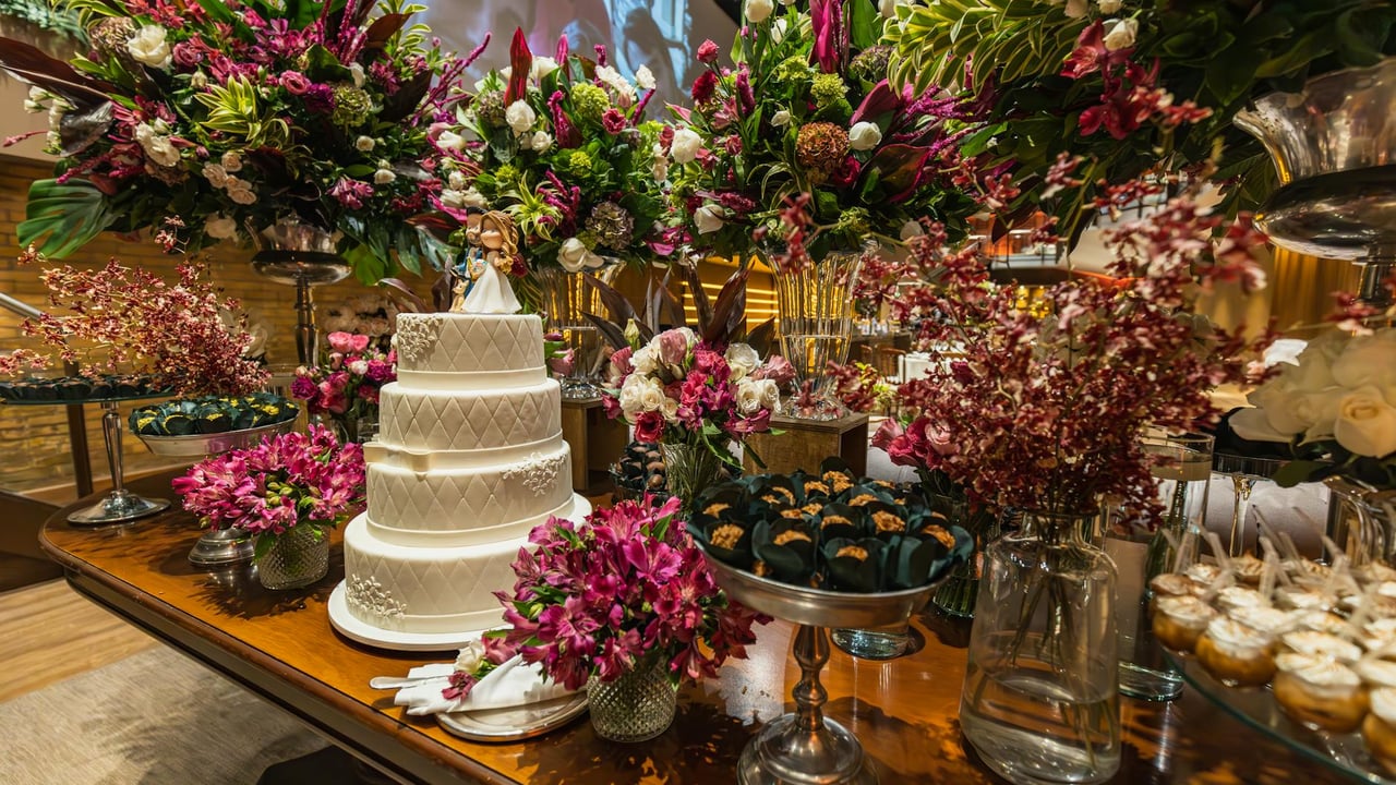 A beautifully decorated wedding cake table with vibrant floral bouquets, creating an elegant celebration ambiance.