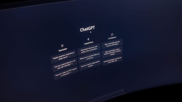 Close-up of a computer screen displaying ChatGPT interface in a dark setting.