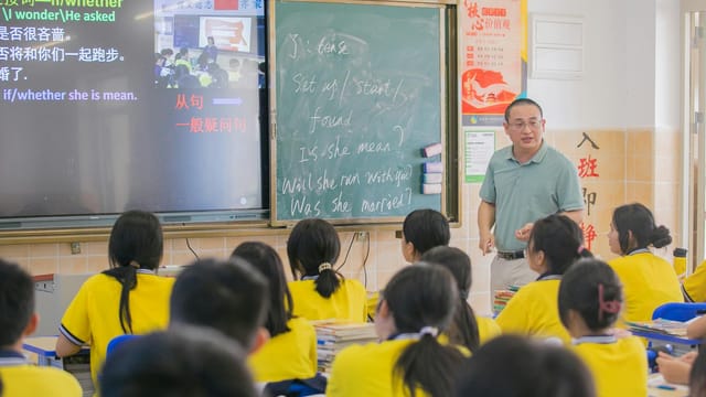 Asian teacher conducts an English lesson in a classroom with students.