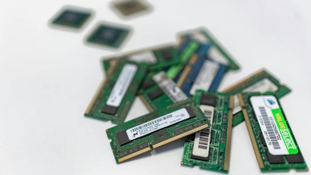 Assorted RAM modules scattered on a white surface, showcasing technology components.