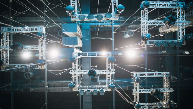 Top view of digital screen under ropes and metal constructions illuminated by shiny lights on stage
