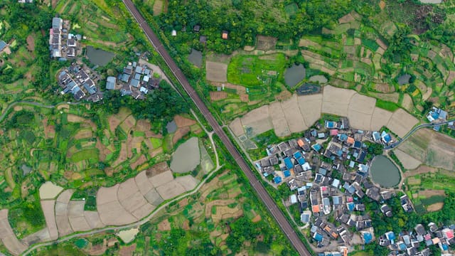 A stunning aerial shot showcasing vibrant green rice terraces and small villages in China.