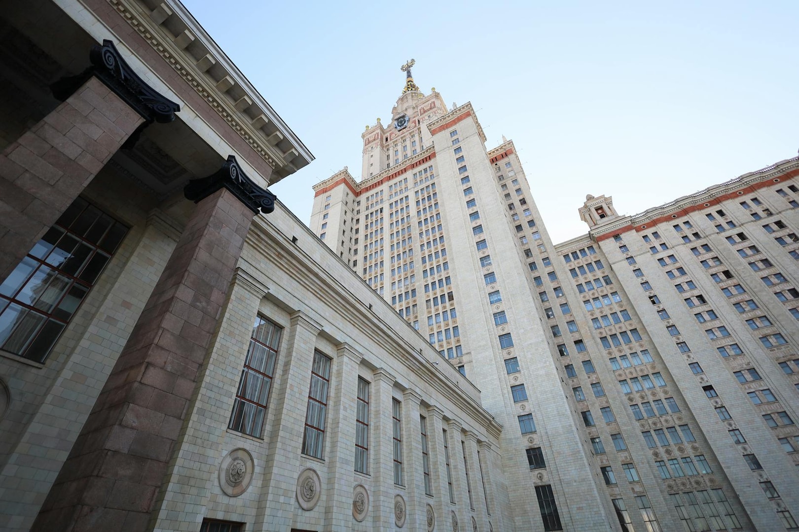 View of the iconic Moscow State University's Lomonosov Tower against a clear sky.