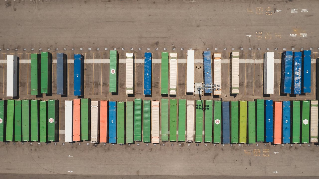 Top view of neatly arranged cargo containers in a shipping port, highlighting logistics and global trade.