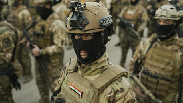 Group of soldiers in tactical gear with helmets and masks, ready for action.