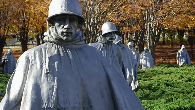 Statues at the Korean War Veterans Memorial surrounded by autumn foliage in Washington, D.C.