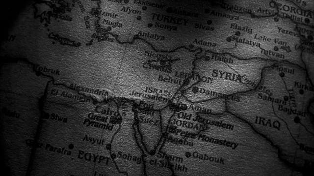 Close-up grayscale image of a map showing countries in the Middle East, including Egypt, Syria, and Iraq.