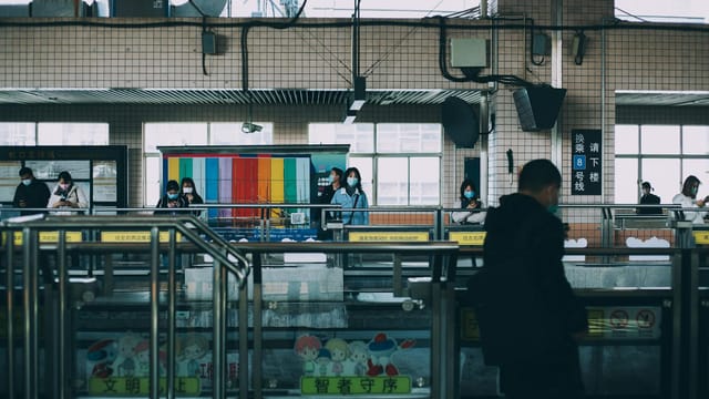 Masked commuters at a Shanghai metro station during the day.