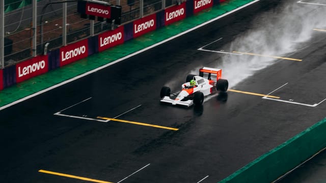 Formula 1 car racing on a wet track with spray, creating dynamic motion and excitement.