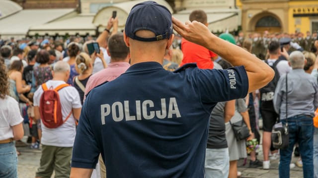 A Polish police officer salutes during a public event in Wrocław, Poland.