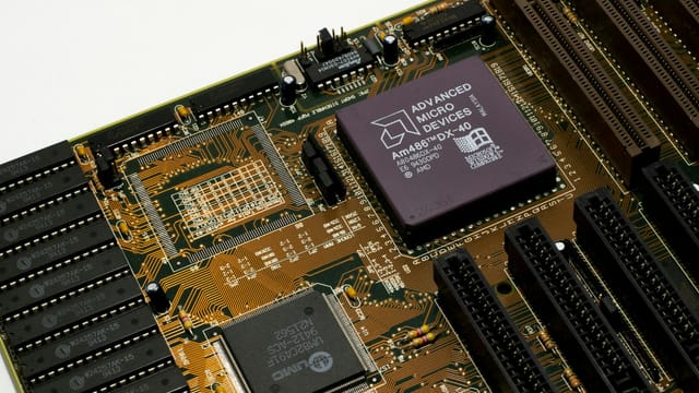 Detailed view of a vintage motherboard with an AMD microchip, showcasing intricate circuitry and slots.