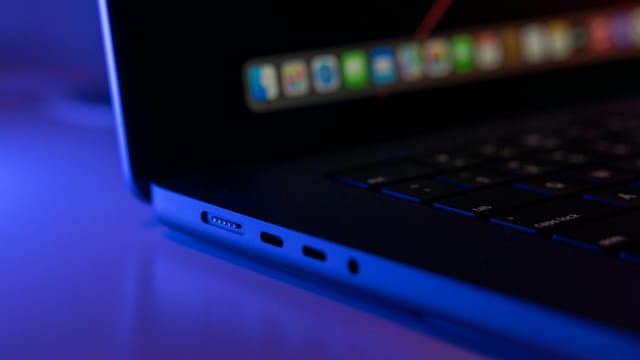 A detailed close-up of a laptop showcasing its ports under cool blue lighting.