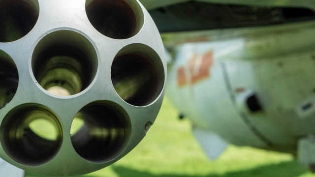 Detailed close-up of an aircraft's gun barrel with blurred background.