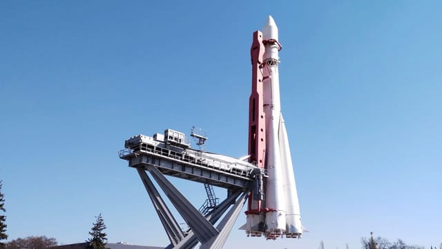 A Soyuz rocket is displayed at Moscow's VDNKh against a clear blue sky.