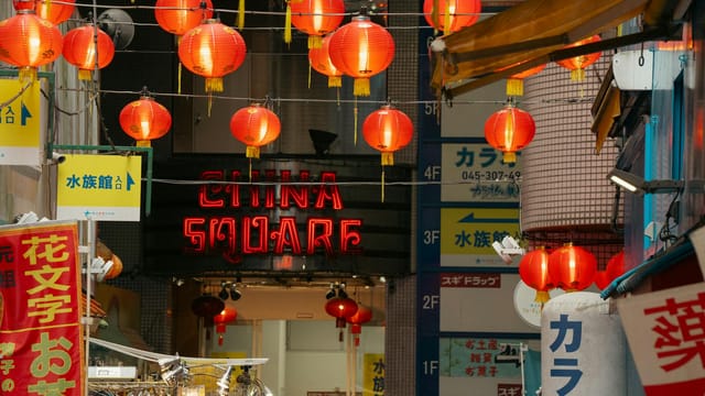 Night market scene with red lanterns and signage at China Square, Yokohama, Japan.